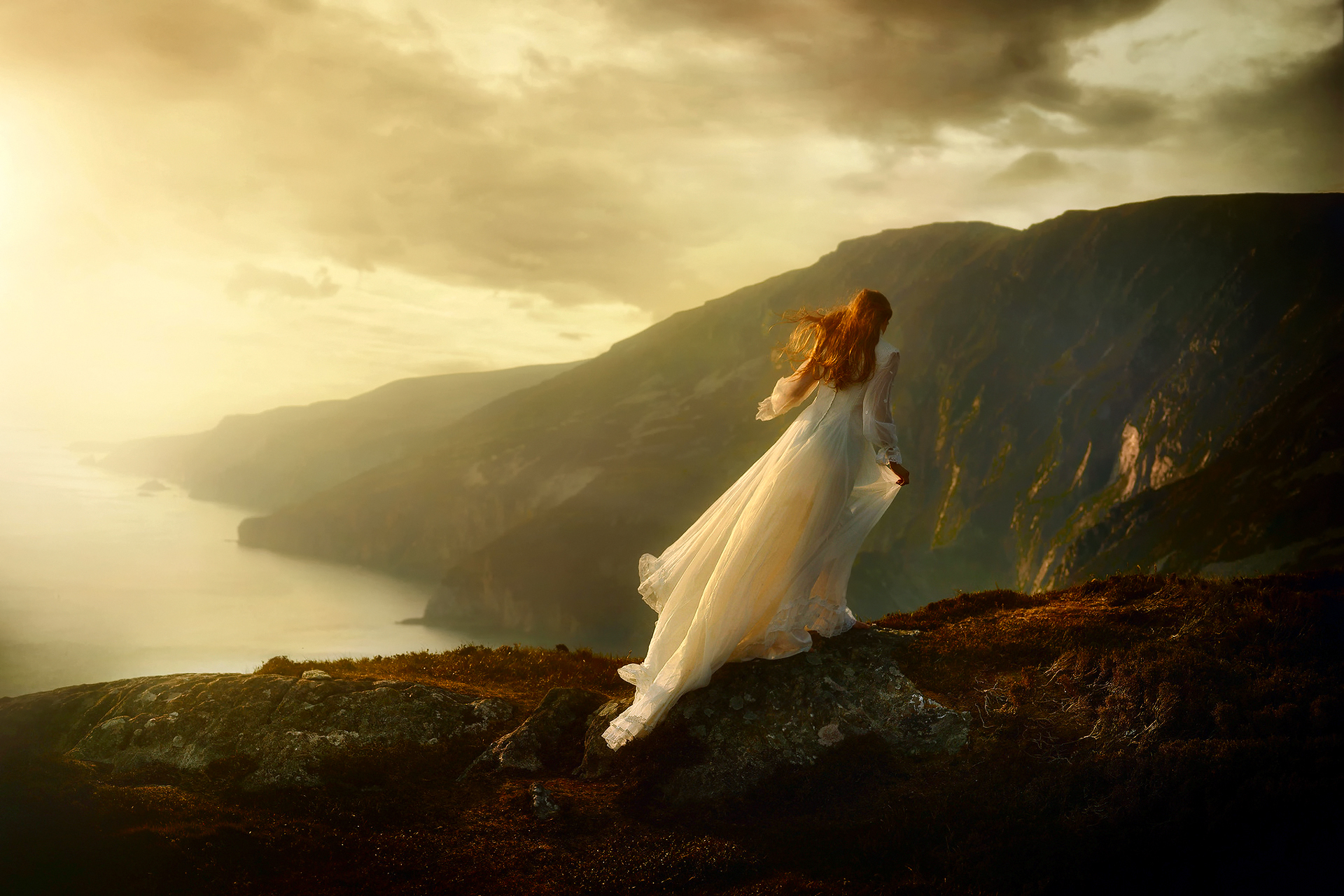 Бежит по краю света великий. Девушка на обрыве. Девушка на скале. Рыжая девушка в горах. Девушка в длинном платье.