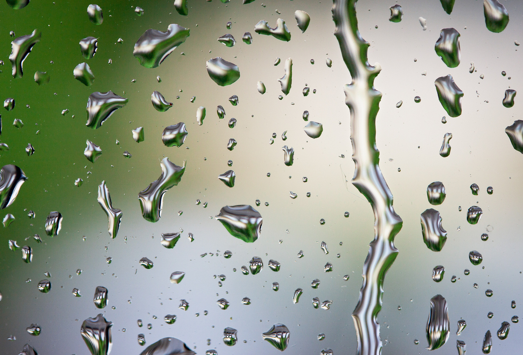 Едва заметно будто капли воды. Капли дождя. Капли на стекле. Дождевые капли на стекле. Капли воды стекают.