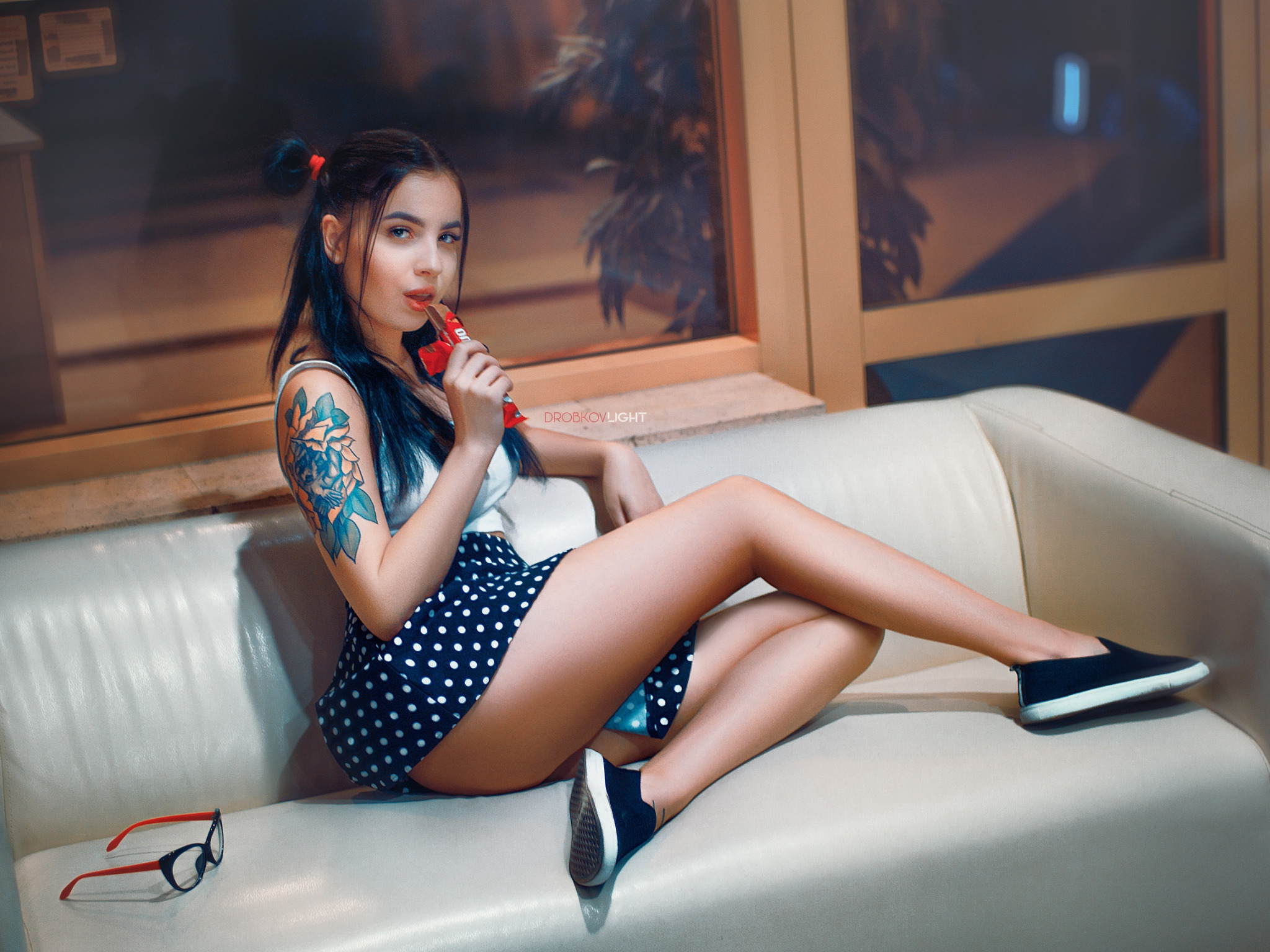 Download wallpaper girl, legs, model, tattoo, brunette, sofa, mini skirt,  candy bar, section girls in resolution 2048x1536