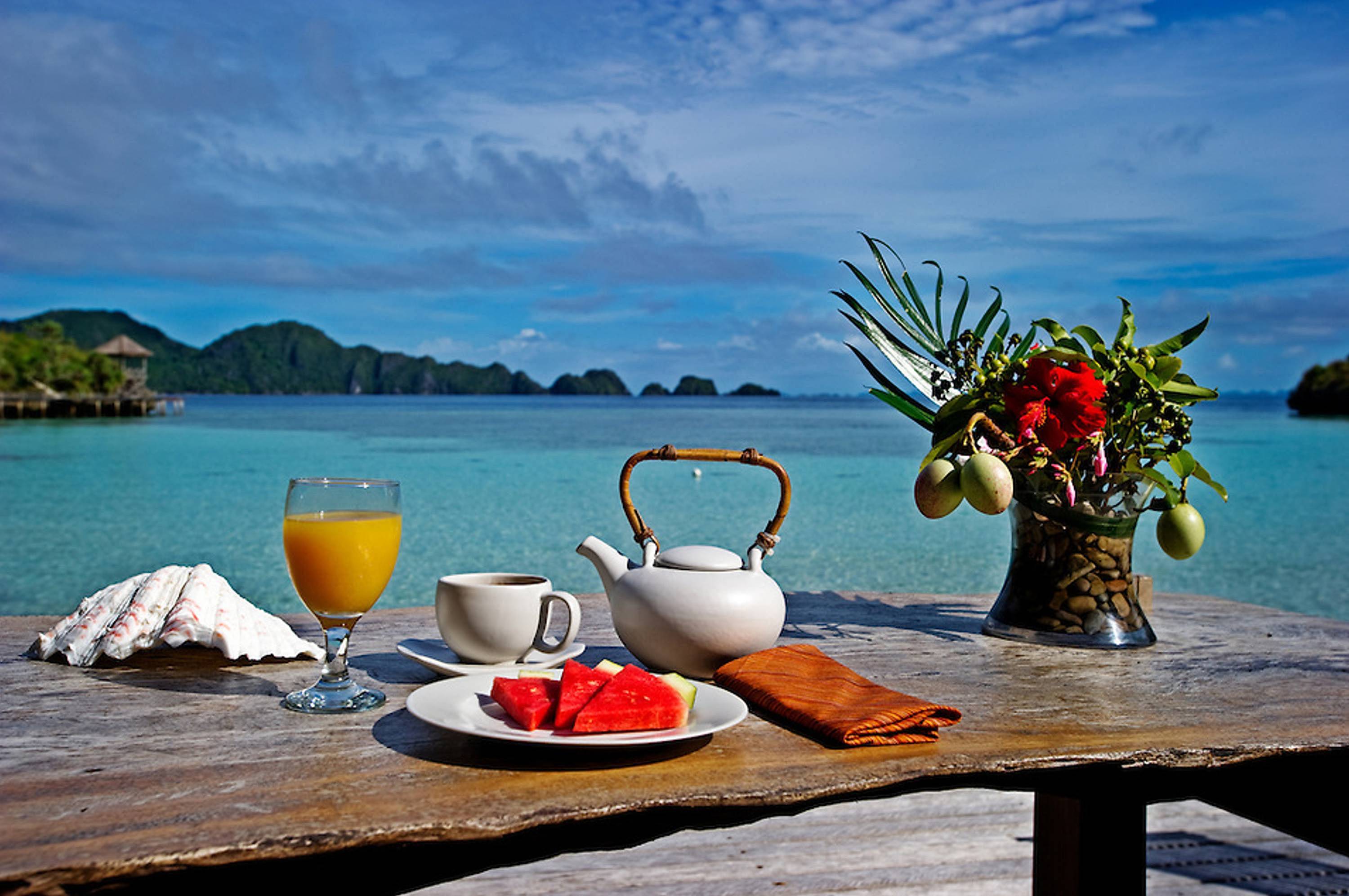 Красивая картинка море утро. Завтрак с видом на море. Столик у моря. Утро на море. Завтрак на побережье.