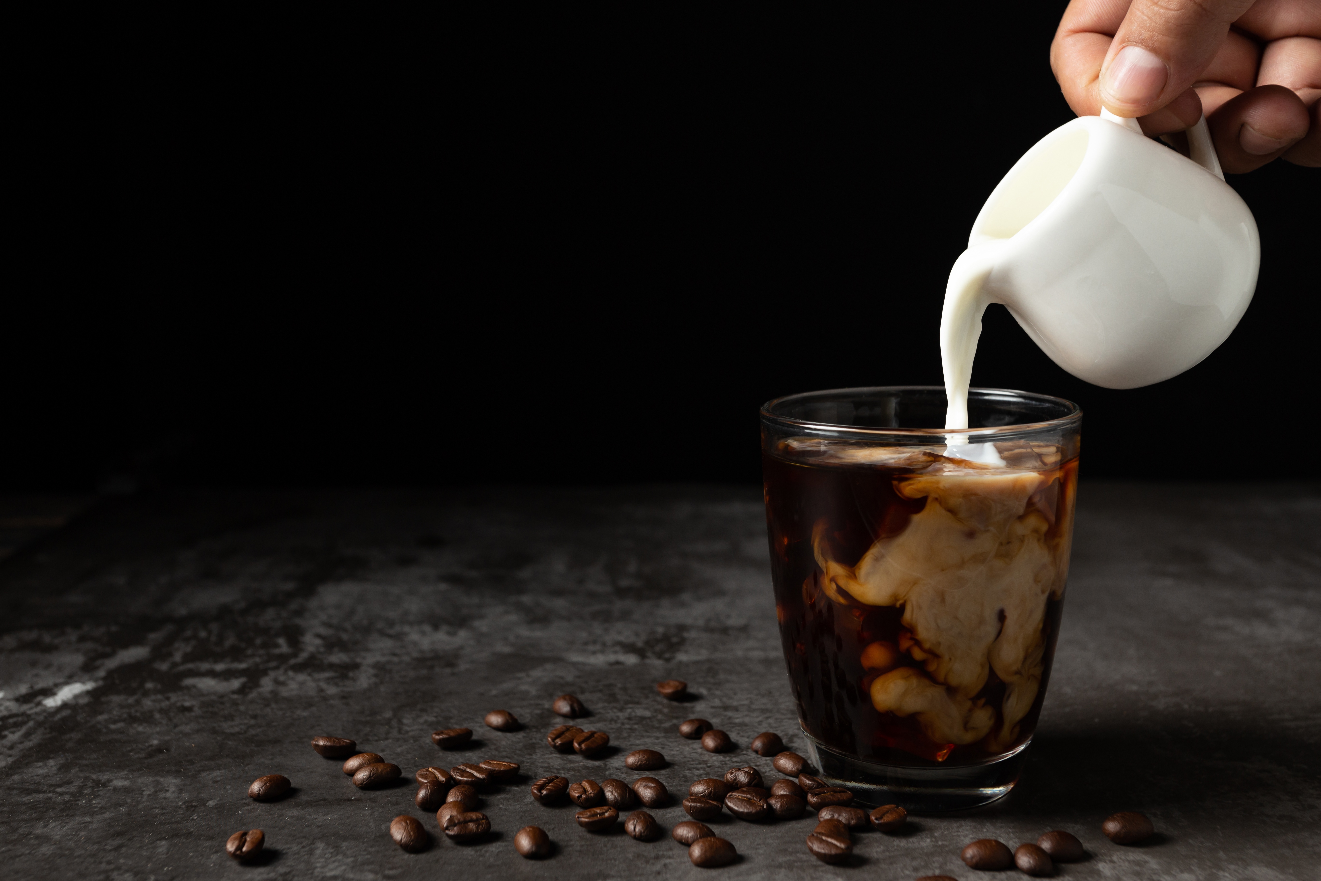 Milky coffee. Кофе. Наливает кофе. Кофе с молоком. Кофе на темном фоне.