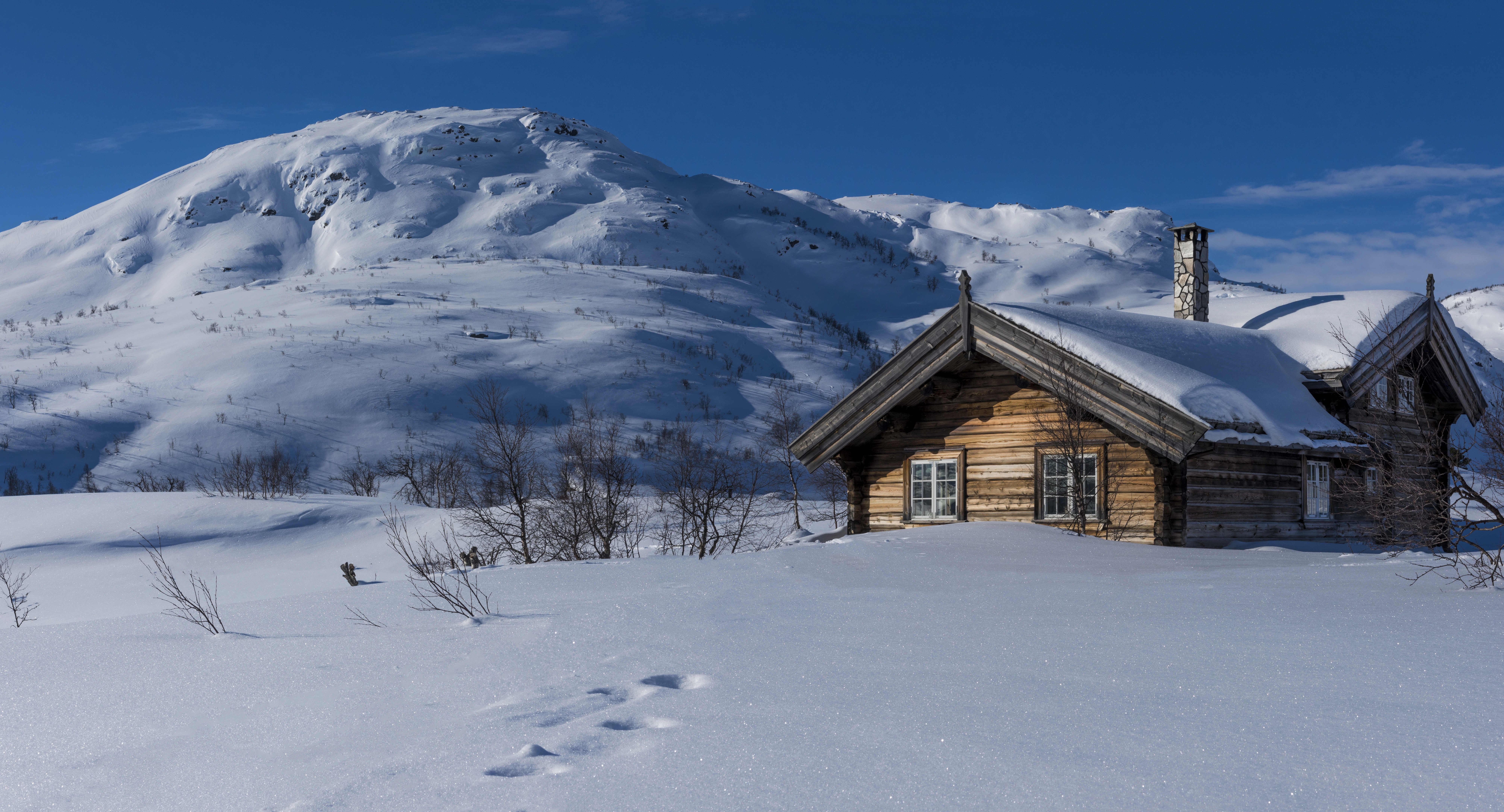 В окрестностях города местами еще лежит снег. Хижина в заснеженных горах Норвегии. Хаттфьелльдал Норвегия избушка. Зимний дом. Дом зимой.