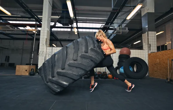 Picture woman, crossfit, giant tire, explosive force