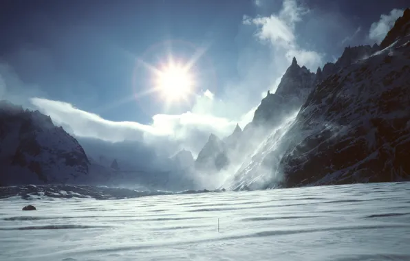 The sun, clouds, snow, mountains