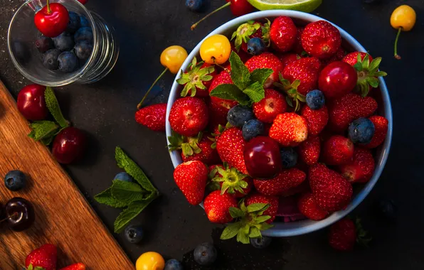 Leaves, cherry, berries, the dark background, glass, blueberries, strawberry, bowl