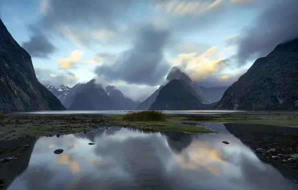 The sky, clouds, mountains, fog, lake, reflection, rocks, shore