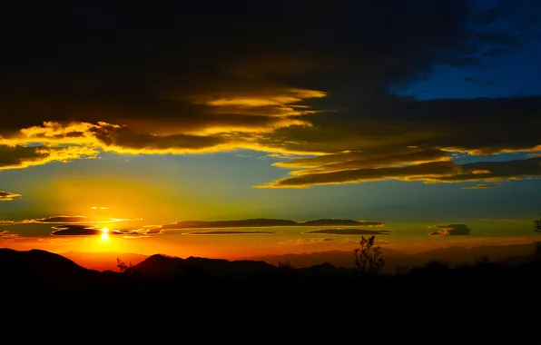 Picture the sky, the sun, sunset, mountains, clouds, horizon, glow