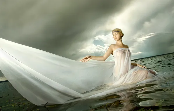 Picture lake, cloudy sky, the girl in the water, translucent white dress
