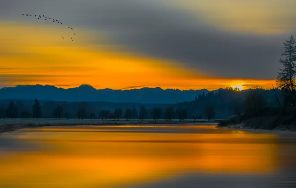 The sky, clouds, trees, sunset, mountains, birds, lake, glow