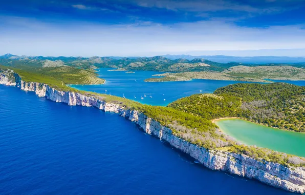 Sea, the sky, the sun, clouds, trees, rocks, shore, lake