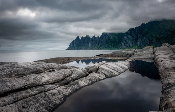 Mountains, clouds, stones, pond, rocky shore, gloomy sky