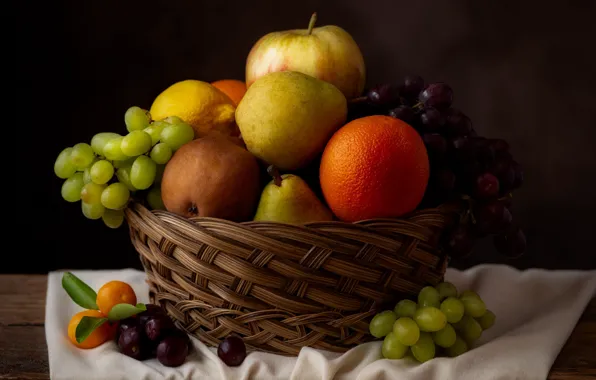 The dark background, table, lemon, apples, orange, towel, grapes, fruit