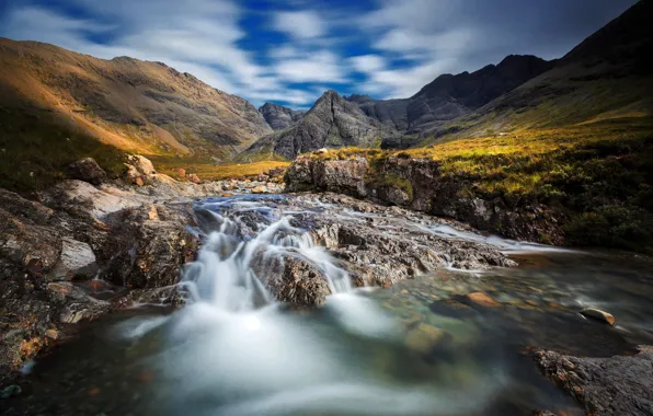 The sky, grass, the sun, clouds, mountains, stream, stones