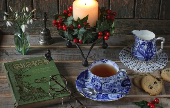 Tea, candle, milk, cookies, glasses, snowdrops, book, still life