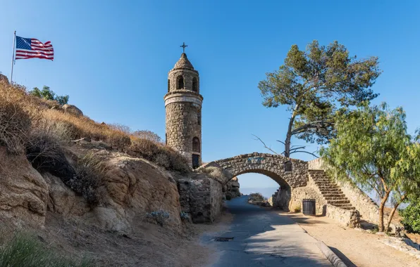 Picture the sky, the sun, trees, mountains, stones, tower, trail, flag