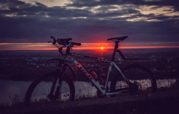 Picture the sky, the sun, clouds, rays, landscape, sunset, bike, the city
