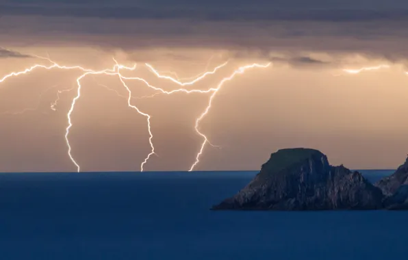 Sea, clouds, rocks, lightning