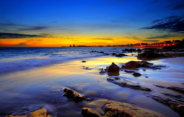 Picture sea, the city, stones, shore, the evening