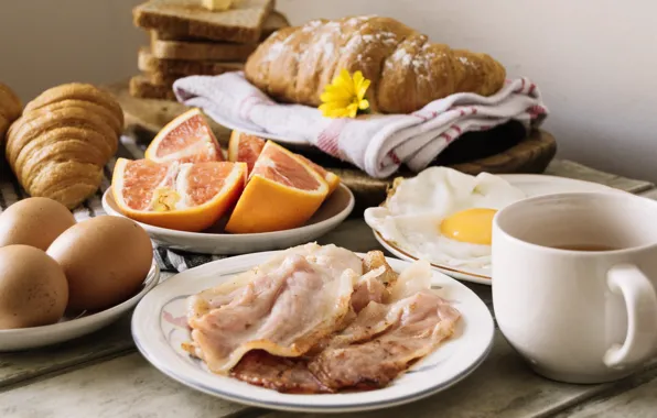 Eggs, bread, citrus, tablecloth, bacon, croissants