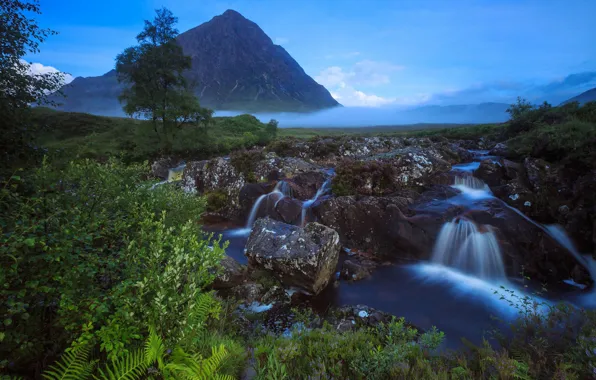 The sky, grass, clouds, trees, mountains, fog, stream, stones