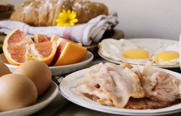 Eggs, bread, citrus, tablecloth, bacon, croissants
