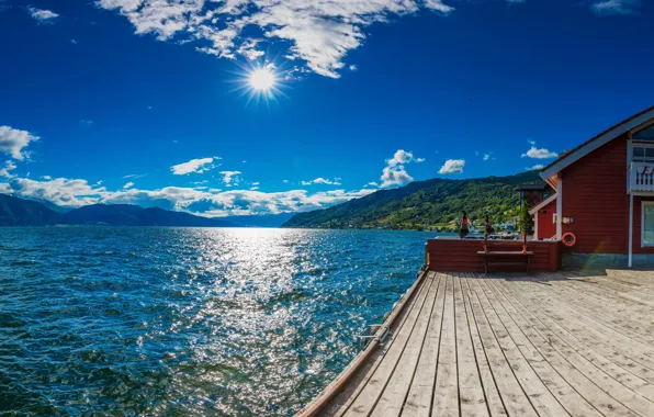 The sky, the sun, clouds, rays, mountains, bird, shore, pier