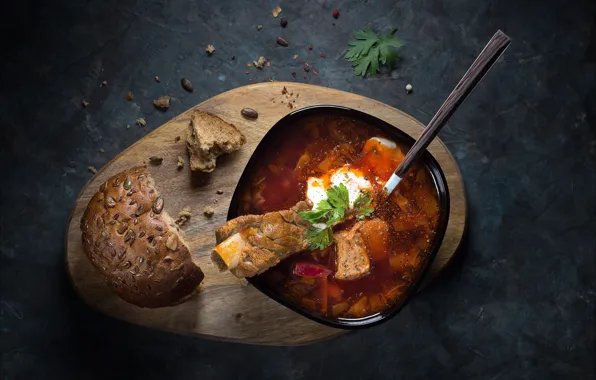 The dark background, bread, spoon, soup, meat, bowl, bone, parsley