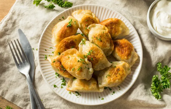 Table, plate, knife, plug, parsley, napkin, sour cream, dumplings