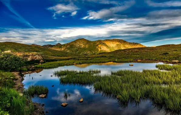 Picture the sky, grass, clouds, mountains, pond