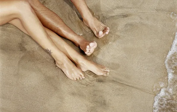 Sand, water, shore, two pairs of legs
