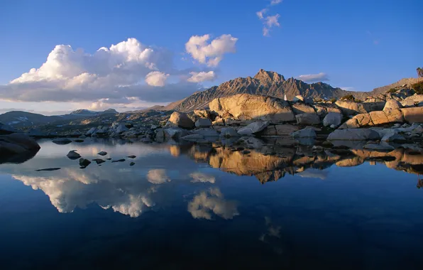 The sky, clouds, sunset, mountains, lake, reflection, stones, rocks