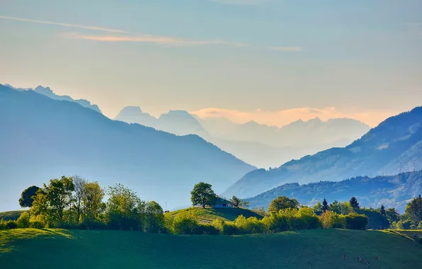 The sky, clouds, trees, mountains, house, hills, haze