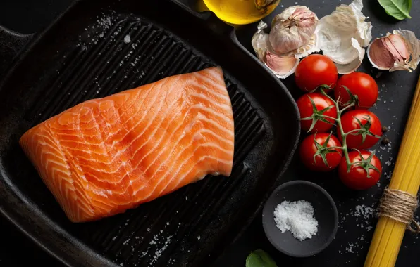 The dark background, fish, vegetables, tomatoes, spaghetti, garlic, salt, pan