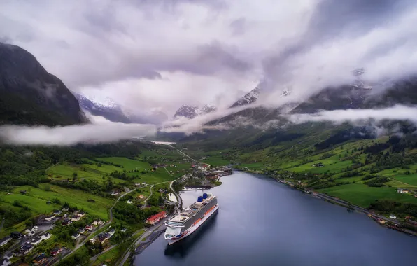 The sky, clouds, fog, shore, the slopes, haze, houses, pond