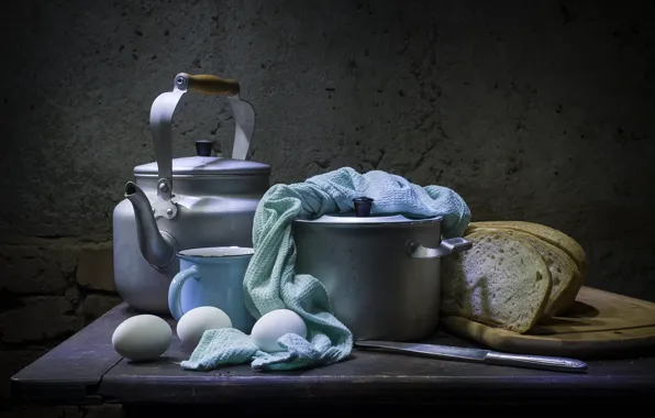 Table, eggs, towel, kettle, bread, knife, mug, dishes