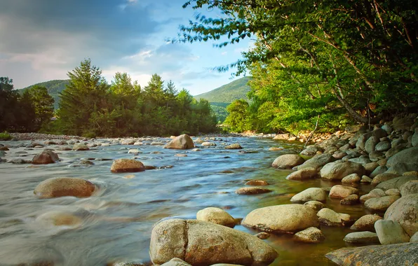 The sky, clouds, trees, mountains, river, stones