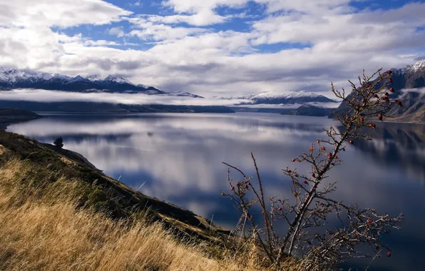 The sky, grass, water, clouds, mountains, lake, surface, shore