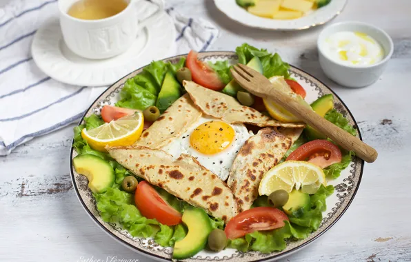 Lemon, scrambled eggs, tomato, olives, salad, avocado, pita
