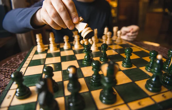 Download A Person Is Playing Chess On A Board Wallpaper