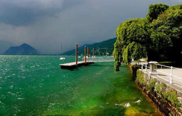 Picture the sun, clouds, trees, mountains, shore, home, yacht, pier