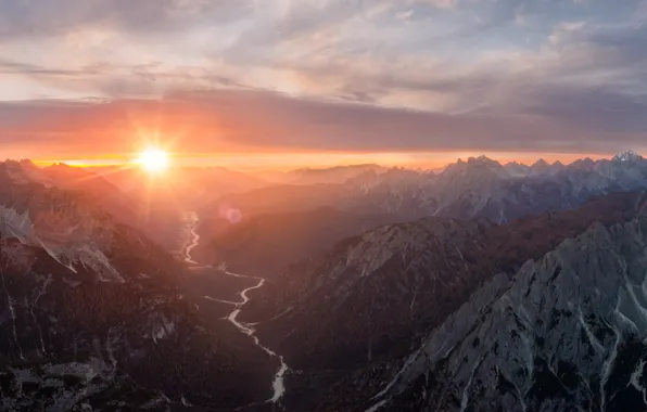 Picture the sky, the sun, clouds, rays, mountains, fog, river, rocks