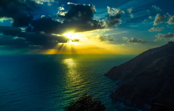 Picture the sky, the sun, rays, mountains, clouds, the ocean, horizon