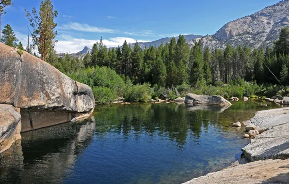 The sky, trees, mountains, lake, stones