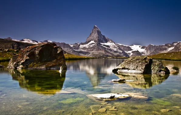 The sky, snow, mountains, lake, stones