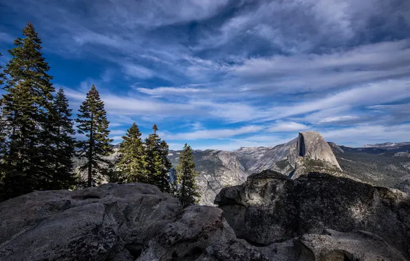 The sky, clouds, trees, mountains, rocks
