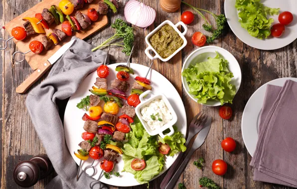 Knife, meat, vegetables, tomatoes, sauce, salad, kebabs