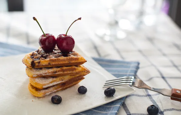 Picture cherry, blueberries, waffles, powdered sugar, chocolate glaze