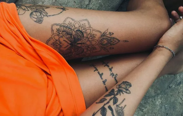 Girl, tan, tattoo, orange dress, slender legs, a chain on his arm, butterfly tattoo