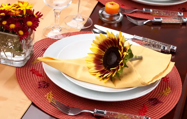 Flowers, sunflower, candles, glasses, plates, knives, napkin, fork