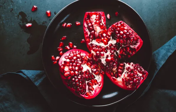 The dark background, plate, fabric, fruit, grenades, garnet, pomegranate grains, broken
